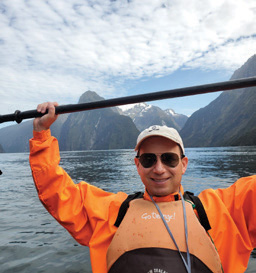 David Danish kayaking with mountains in the background.