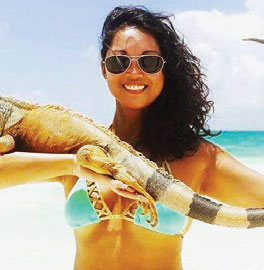Maria Remington in a bathing suit holding an iguana