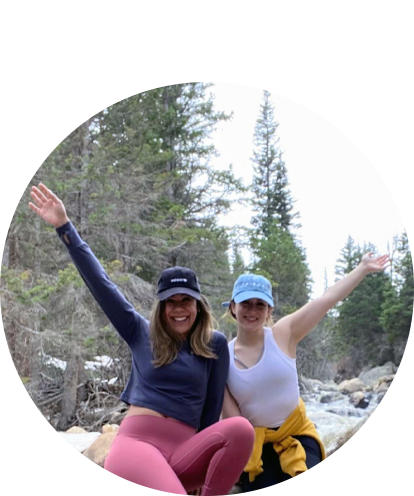 Vanessa Contreras fun photo with female friend waiving from a riverbed in woods/forest.