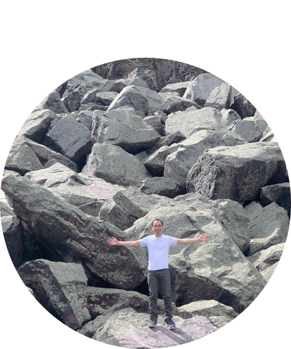 Elliot Fu fun photo posing with arms open with backdrop of boulders.