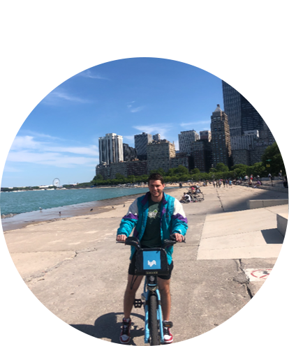 Jordan Angle fun photo on rental bike next to Lake Michigan with Chicago skyline in background. Sunny day.