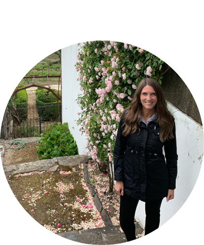 Katherine Mosher fun photo posing behind a blooming vine.