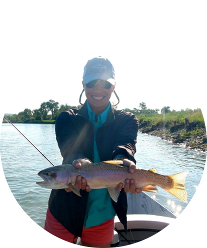 Logan Menne fun photo posing on a boat with a fish held in both hands on a sunny day.