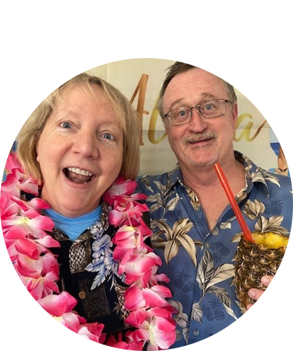 Nansen Smith fun photo posing with adult female wearing Hawaiian leis and tropic print shirts.