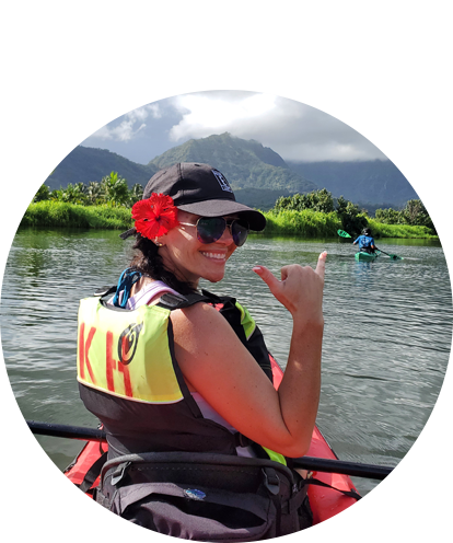 Shanna Pope fun photo kayaking in body of water with mountains in the background.