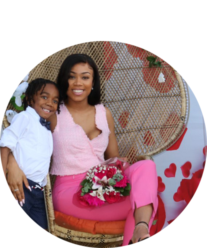 Jaslene Washington fun photo posing with young child with flowers in lap.