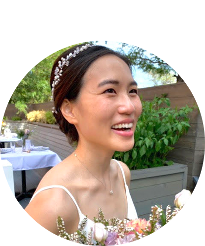 Eumie Kim fun photo smiling in wedding dress holding a bouquet of flowers.