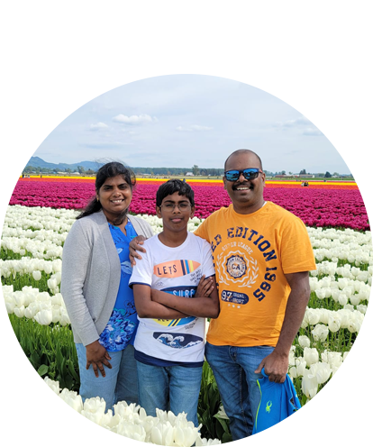 Sangeetha Kuppusamy fun photo posing in field of tulips with adult male and teenage male.