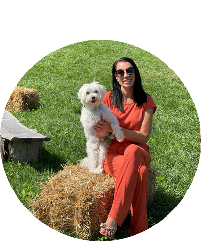 Haley Goeller fun photo (adult female posing with dog while sitting on a bale of hay on a sunny day).