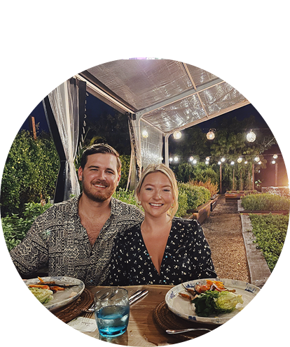 Hayley Rawers fun photo (adult female and adult male sitting at table with food under outdoor tent at night).