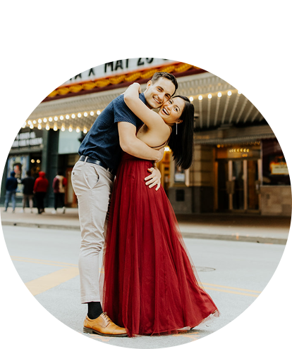 Roman Orozov fun photo embracing adult female in front of Chicago Theatre.