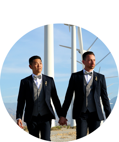 Timothy Colgan fun photo holding hands with husband behind windmills in the desert.