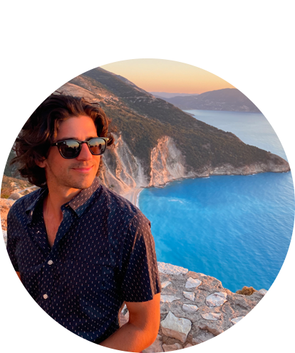 Dean Karras fun photo (adult male with sunglasses posing on a seaside mountain during sunset hours).