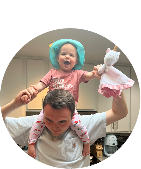 Man posing with smiling baby on shoulders