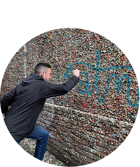 Man posing next to gum wall