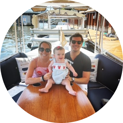 Woman with baby and husband on a boat smiling